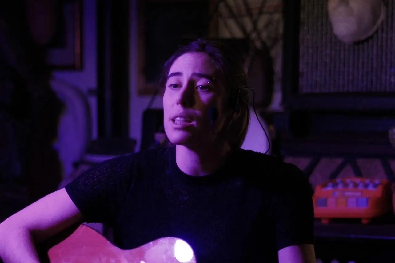 Gaber sotto le stelle, Valentina Luporini canta con la chitarra in luce viola