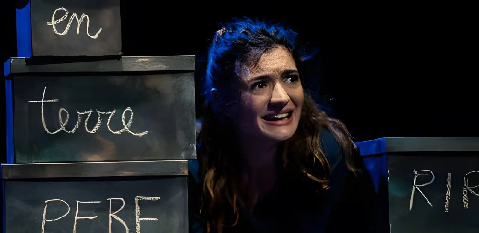 Tutte queste ossa fragili qui riunite, teatro d'oggetti: un'attrice tra scatole di legno con scritte a gesso